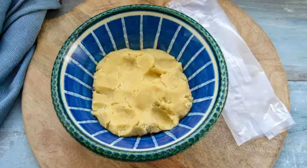 Frischer quiche teig in einer blauen Schüssel, bereit für die Zubereitung einer herzhaften Tarte.