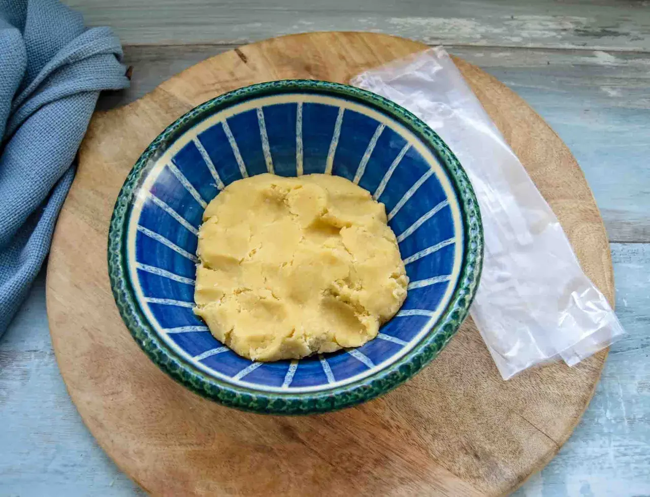 Frischer quiche teig in einer blauen Schüssel, bereit für die Zubereitung einer herzhaften Tarte.
