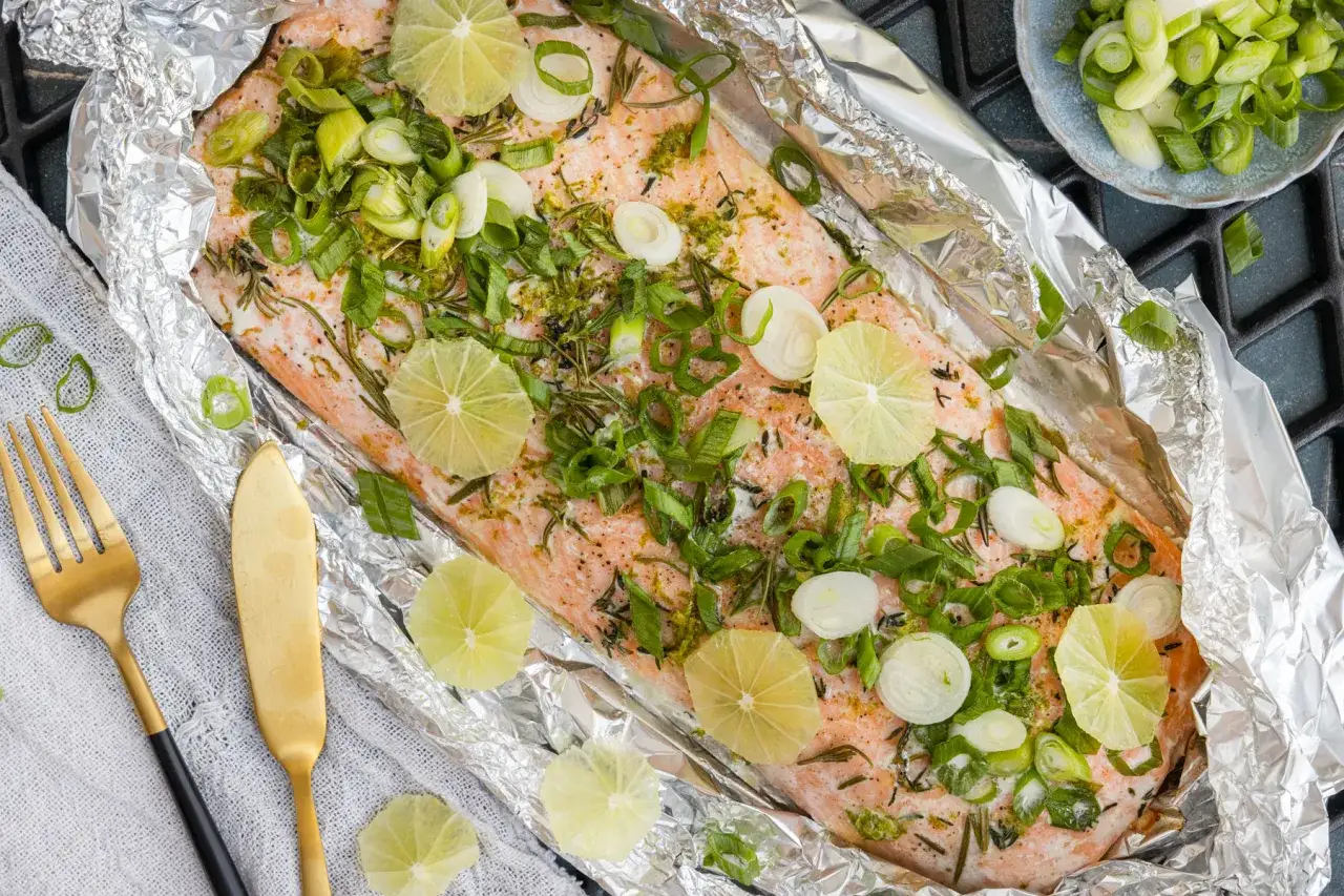 Lachsfilet grillen in Alufolie mit Limettenscheiben und Fr&uuml;hlingszwiebeln. Ein k&ouml;stliches Gericht, bereit f&uuml;r den Grill.