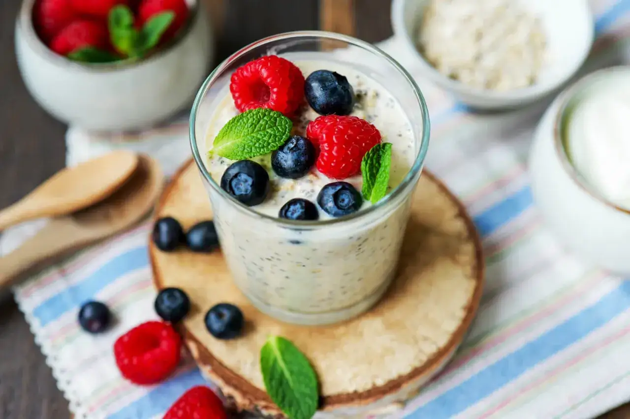 Ein Glas mit Overnight Oats mit Joghurt, garniert mit frischen Beeren und Minze. Perfekt f&uuml;r ein gesundes Fr&uuml;hst&uuml;ck.