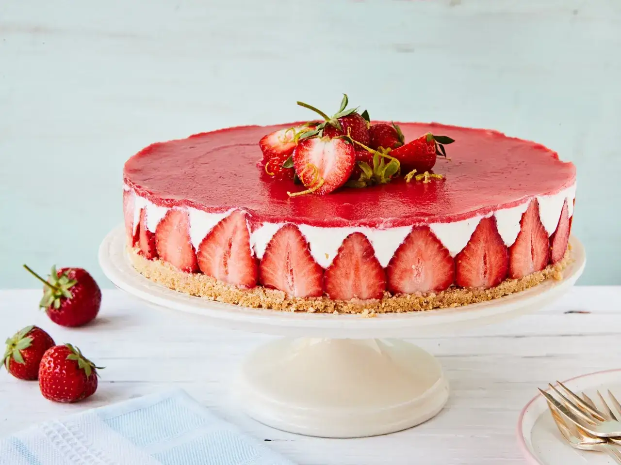 Kuchen ohne backen mit Keksboden: Ein k&ouml;stlicher Erdbeerkuchen mit Frischk&auml;sef&uuml;llung und rotem Fruchtspiegel, dekoriert mit frischen Erdbeeren.
