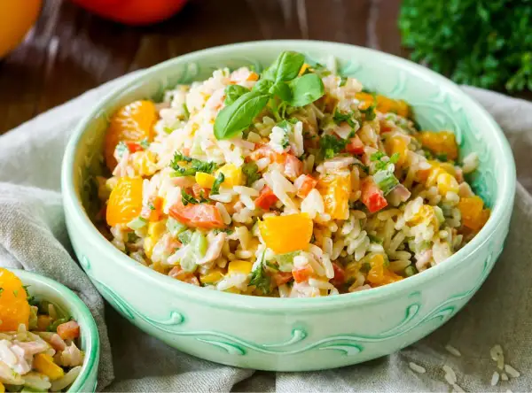 Erfrischender Reissalat mit Orangenstücken, Paprika und Kräutern. Ein leichtes und leckeres Reissalat Rezept für den Sommer.